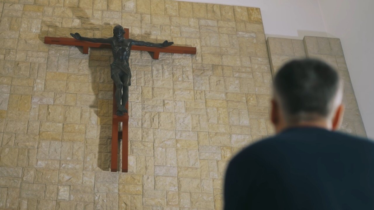 Mężczyzna stojący przed krzyżem w filmie Powołany